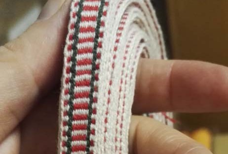 Etelä-Pohjanmaan naisen tarkistettu kansallispuku, pirtanauha, käsinkudottu