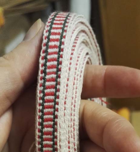 Etelä-Pohjanmaan naisen tarkistettu kansallispuku, pirtanauha, käsinkudottu