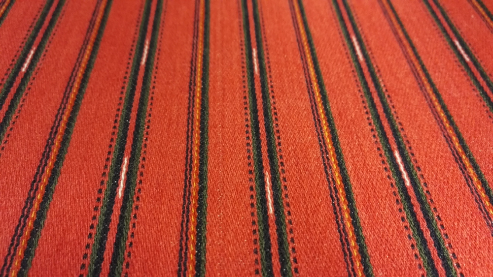 Säkylän naisen tarkistetun kansallispuvun liivikankaassa on flammu- ja ripsiraitoja.