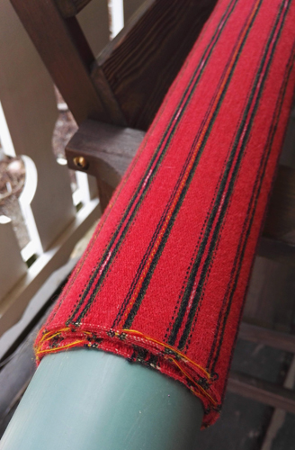 Käsin kudottua kansallispukukangasta kuivumassa rullalla.